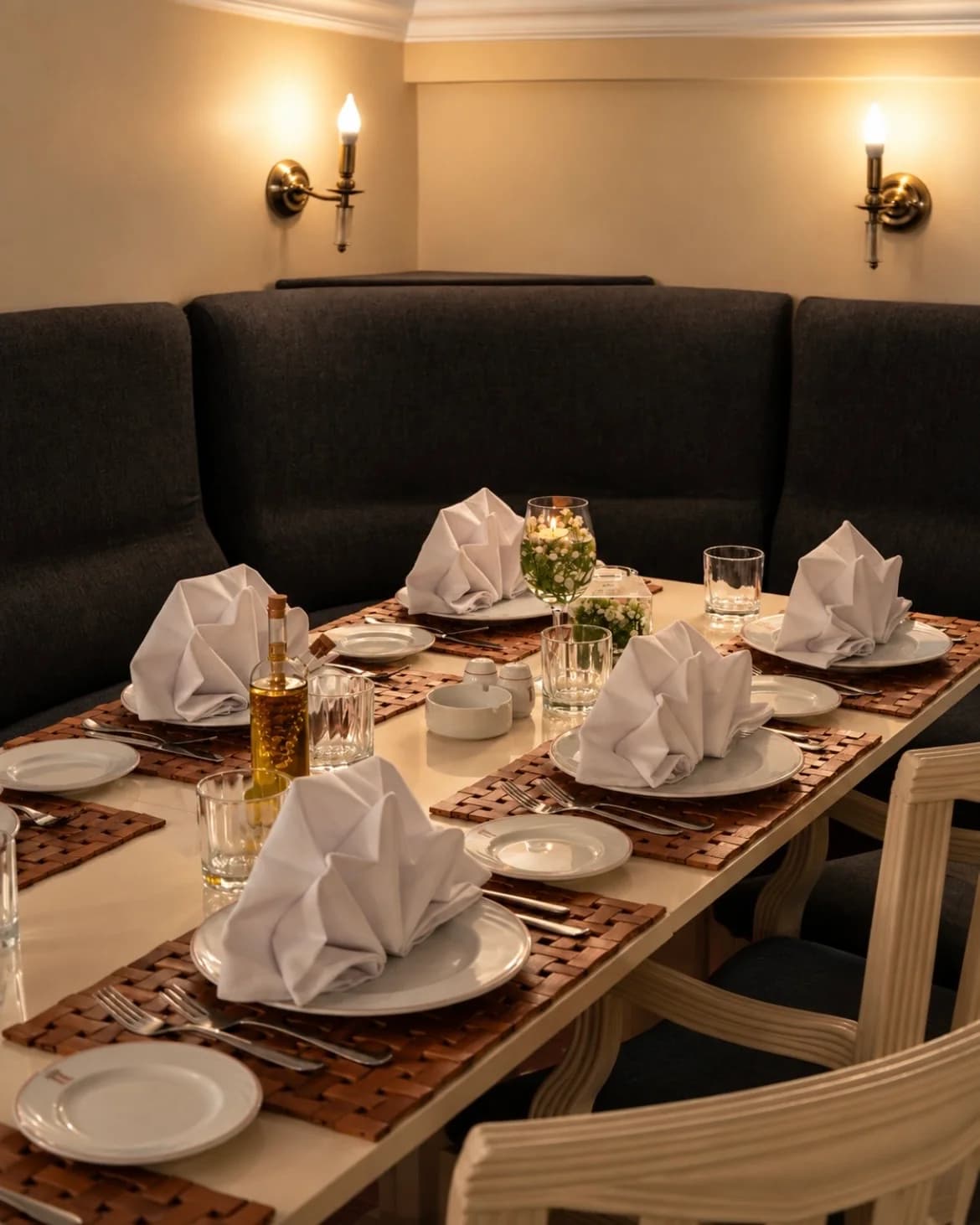 Le salon privé, banquette sombre et table dressée sous les appliques.
